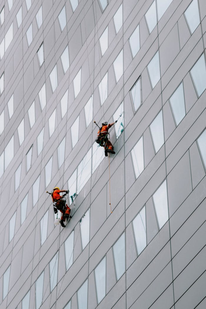 High-rise facade window cleaning on a modern skyscraper for urban maintenance.